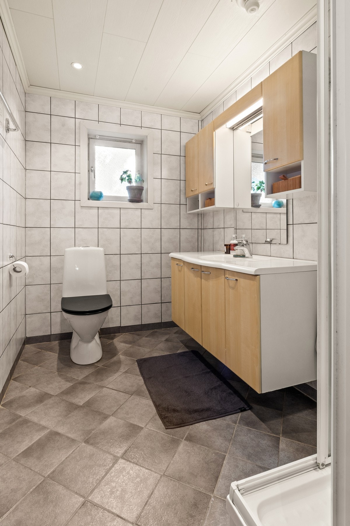 Badet i 1.etasje har innredning med nedfelt servant, gulvfestet toalett og dusjkabinett. Galleribilde