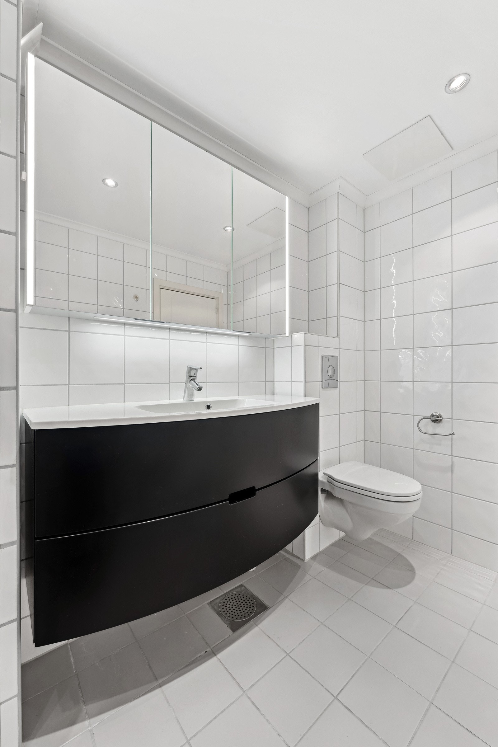 Badet er utstyrt med pen baderomsinnredning og veggmontert klosett. Galleribilde