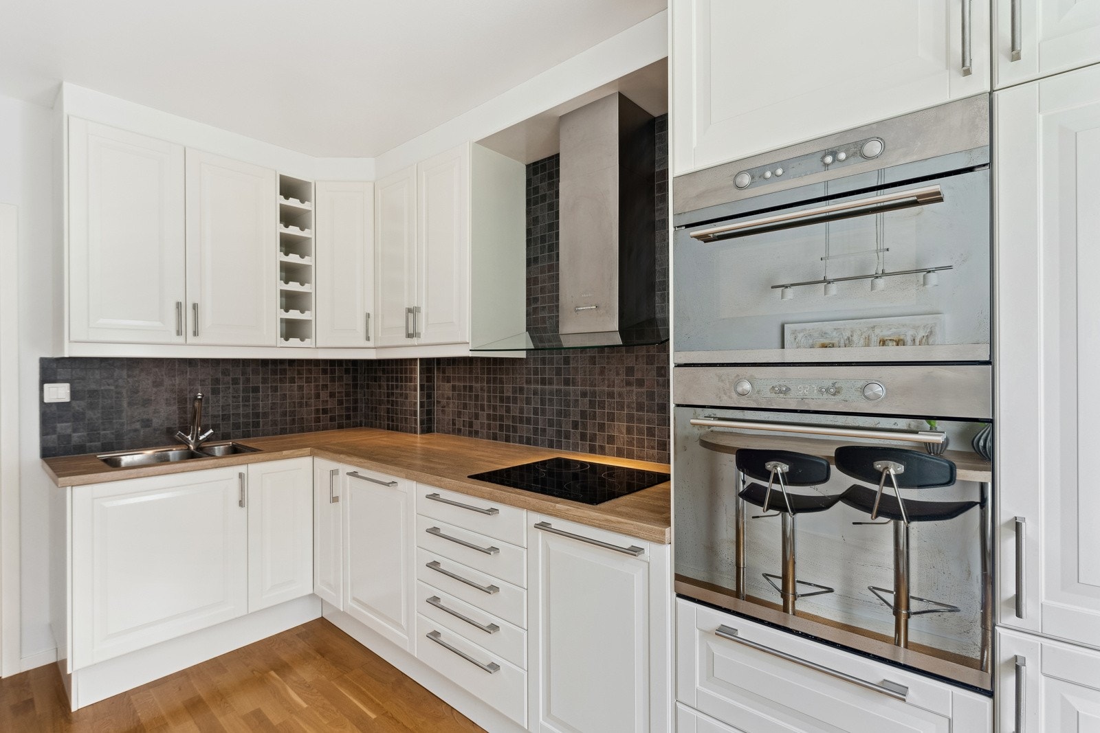 Kjøkken fra 2010 med laminat benkeplate med fliser over benk. Galleribilde