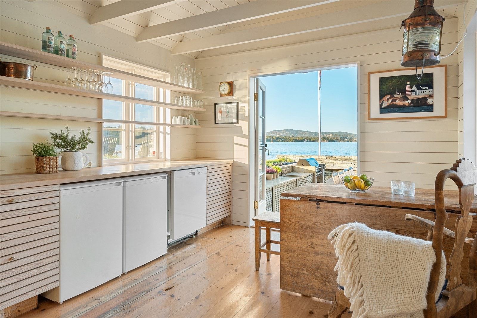 Kjøkkeninnredning med heltre spiler, heltre benkeplate, opplegg for oppvaskmaskin og varmtvannsbereder. Galleribilde