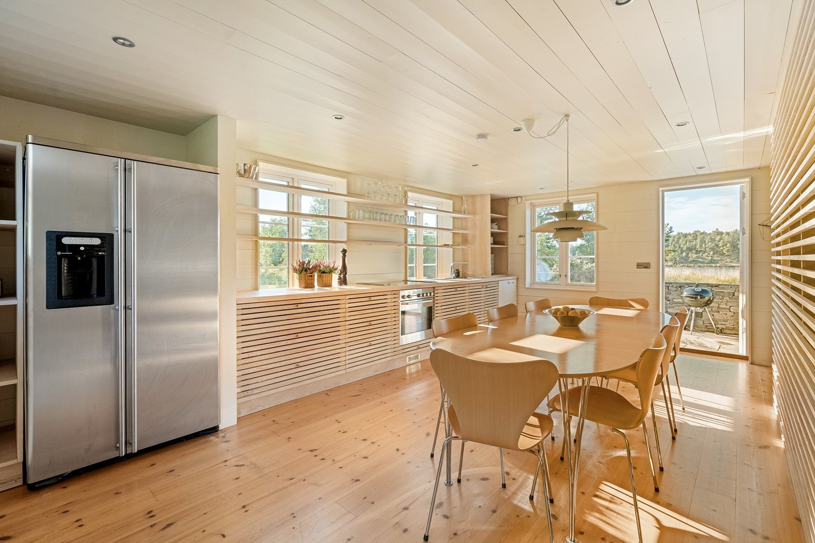 Romslig og flott kjøkken med kjøkkeninnredning i liggende spiler, heltre benkeplate med nedfelt vaskekum, samt integrert koketopp og stekeovn. Galleribilde