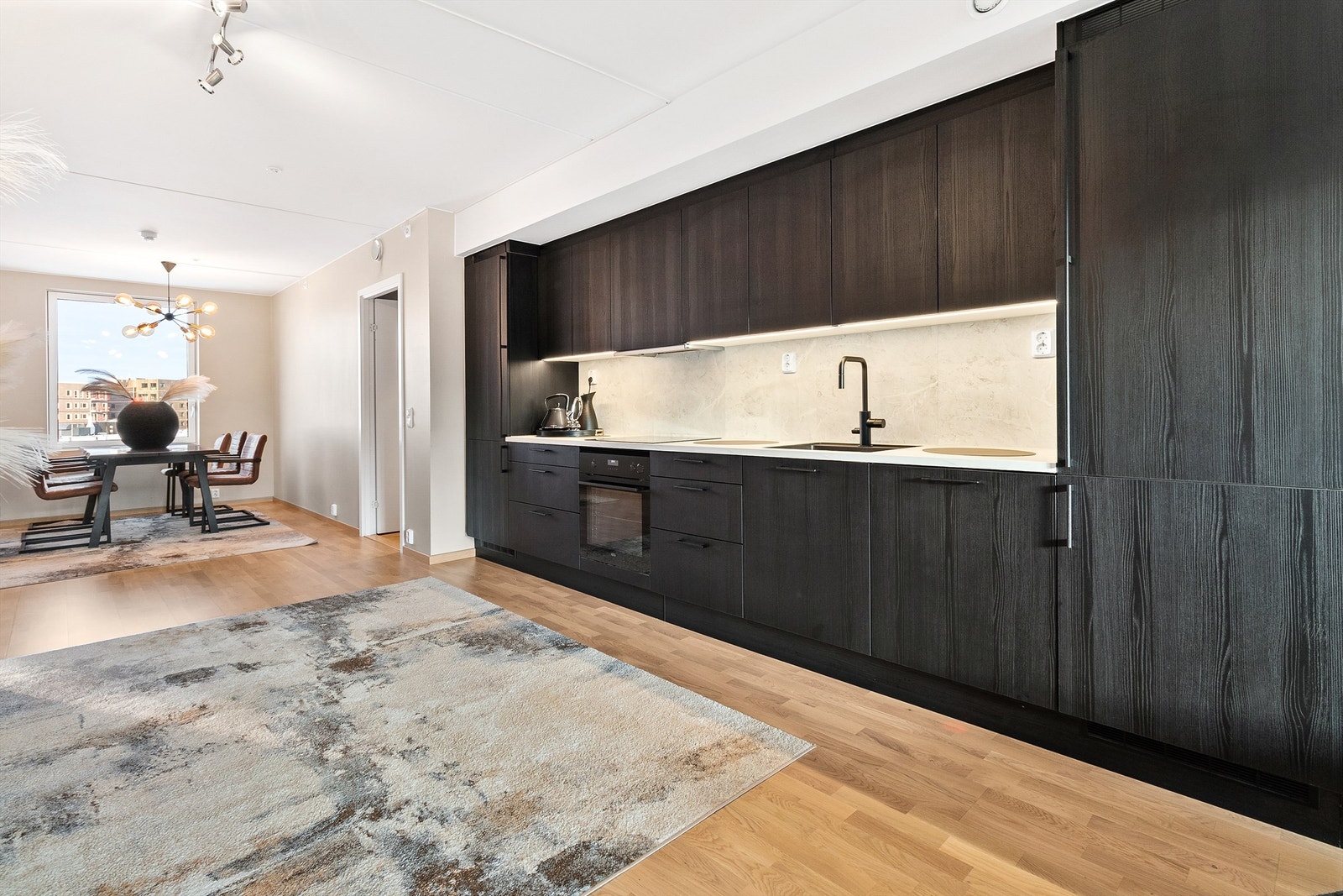 Kjøkkenet ligger i en åpen og sosial løsning med stuen - perfekt for å varte opp gjester Galleribilde