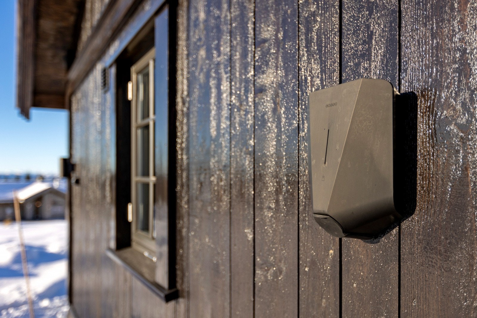 Det er installert elbil-lader på hytteveggen. Galleribilde