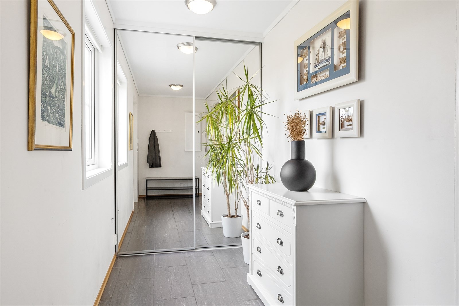 Velkommen inn! Lys og innbydende entré med fliser på gulv, gulvarme og skyvedørsgarderobe med god plass for hele familiens yttertøy. Galleribilde