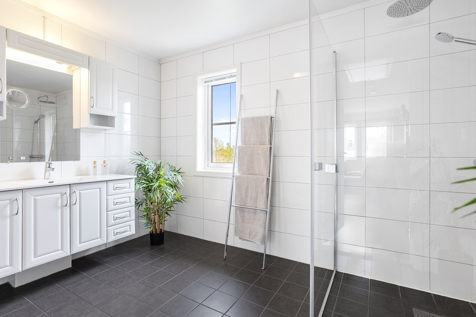 Delikat og romslig bad i 2. etasje med moderne uttrykk, flislagte overflater og elektrisk gulvvarme Galleribilde