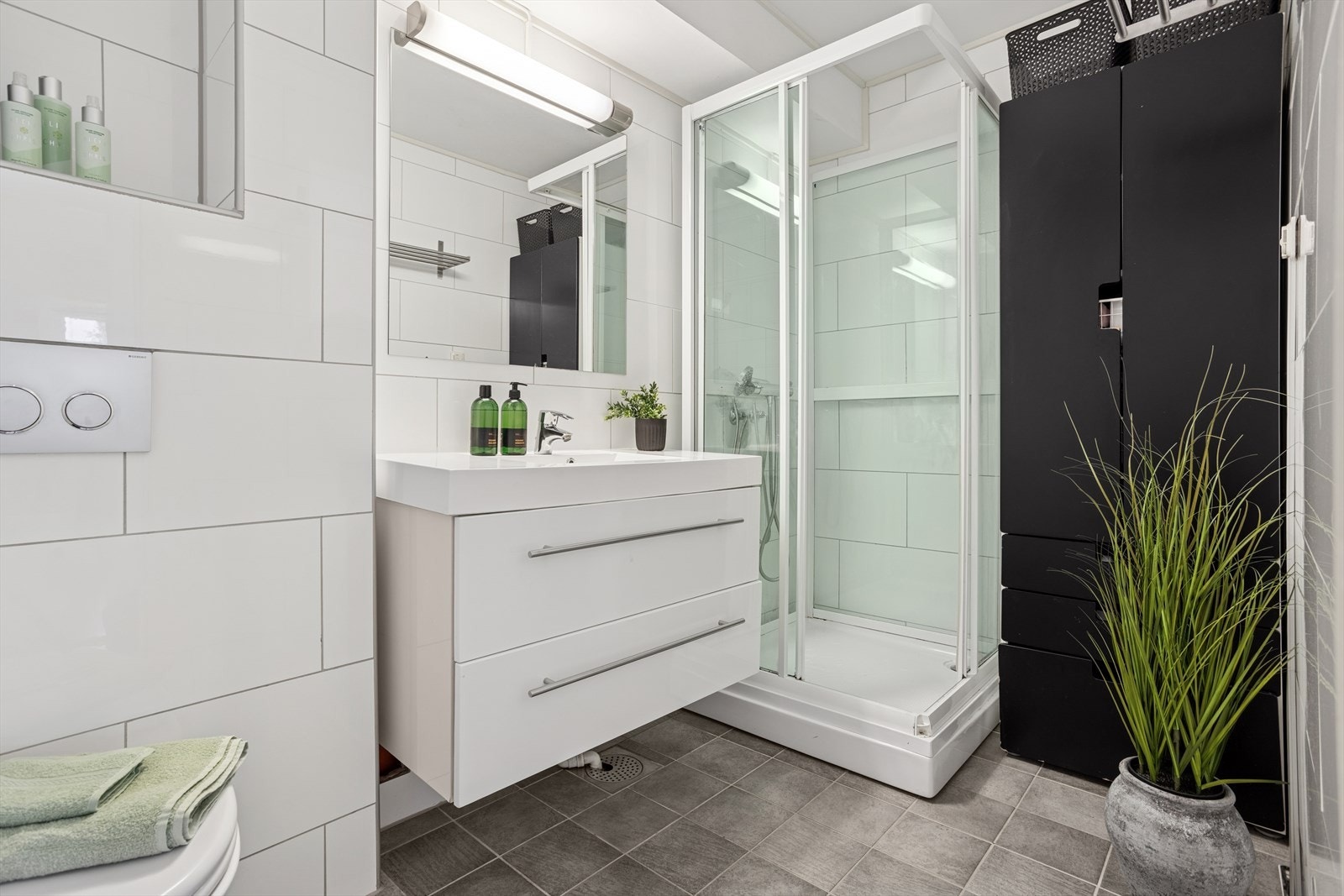 Dusjkabinett, vask med underskap og oppbevaring for toalettsaker. Galleribilde