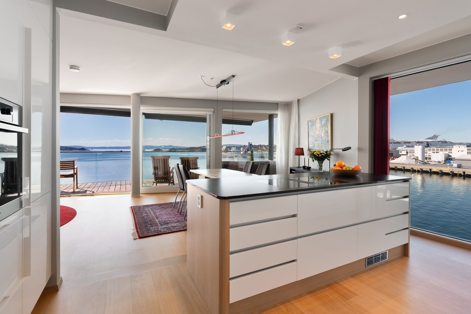 Kjøkkenet ligger i åpen løsning mot stuen, og de store vinduene mot begge sider gir mye lys og luft inn Galleribilde