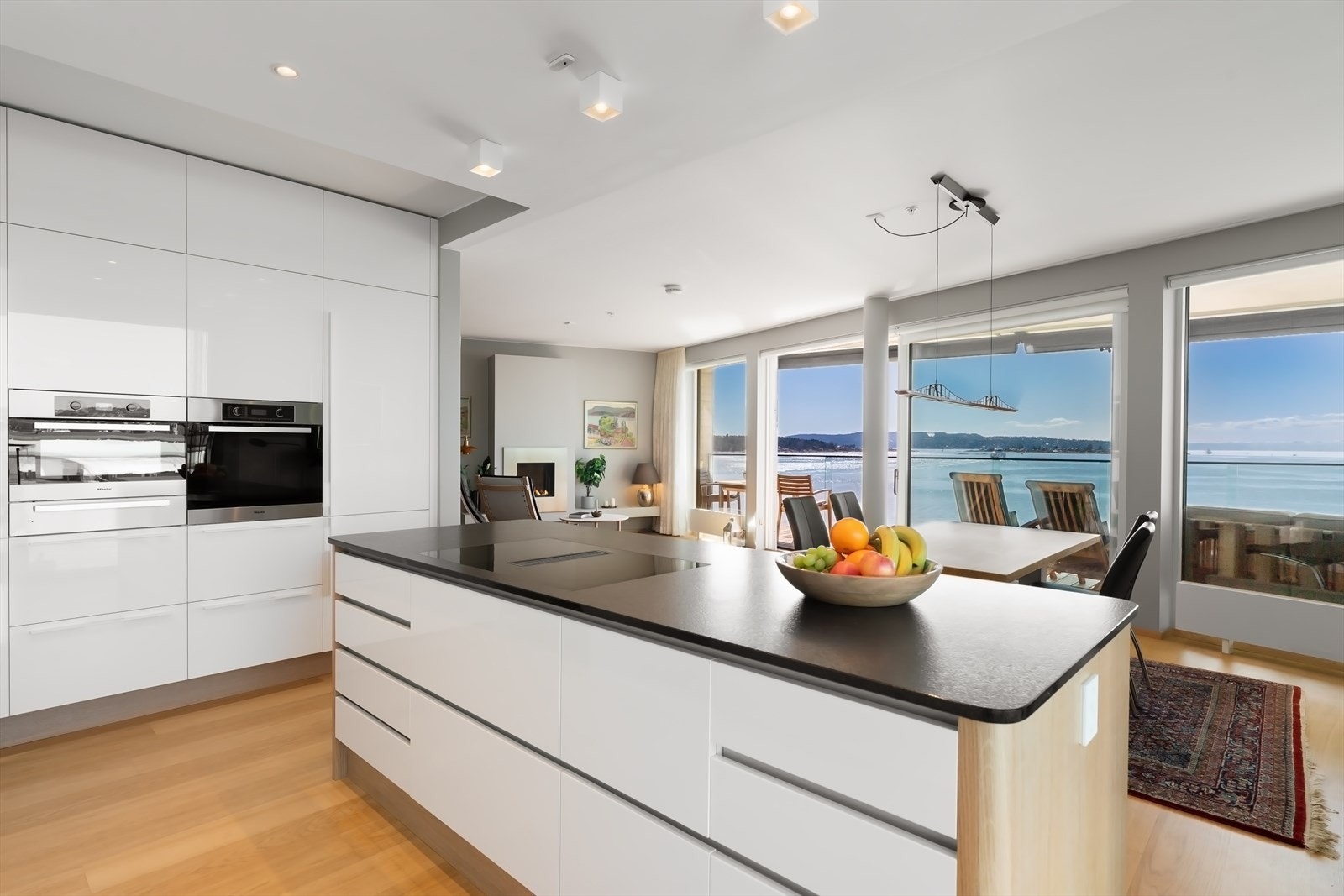 Skuffer og skap har stilrene, hvite høyglansfronter som gir et moderne uttrykk Galleribilde