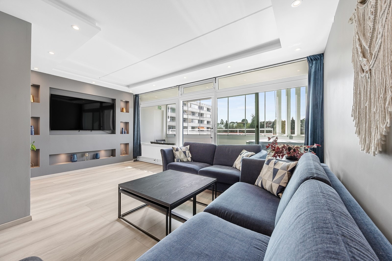 Romslig stue med moderne innebygd TV-løsning. Galleribilde