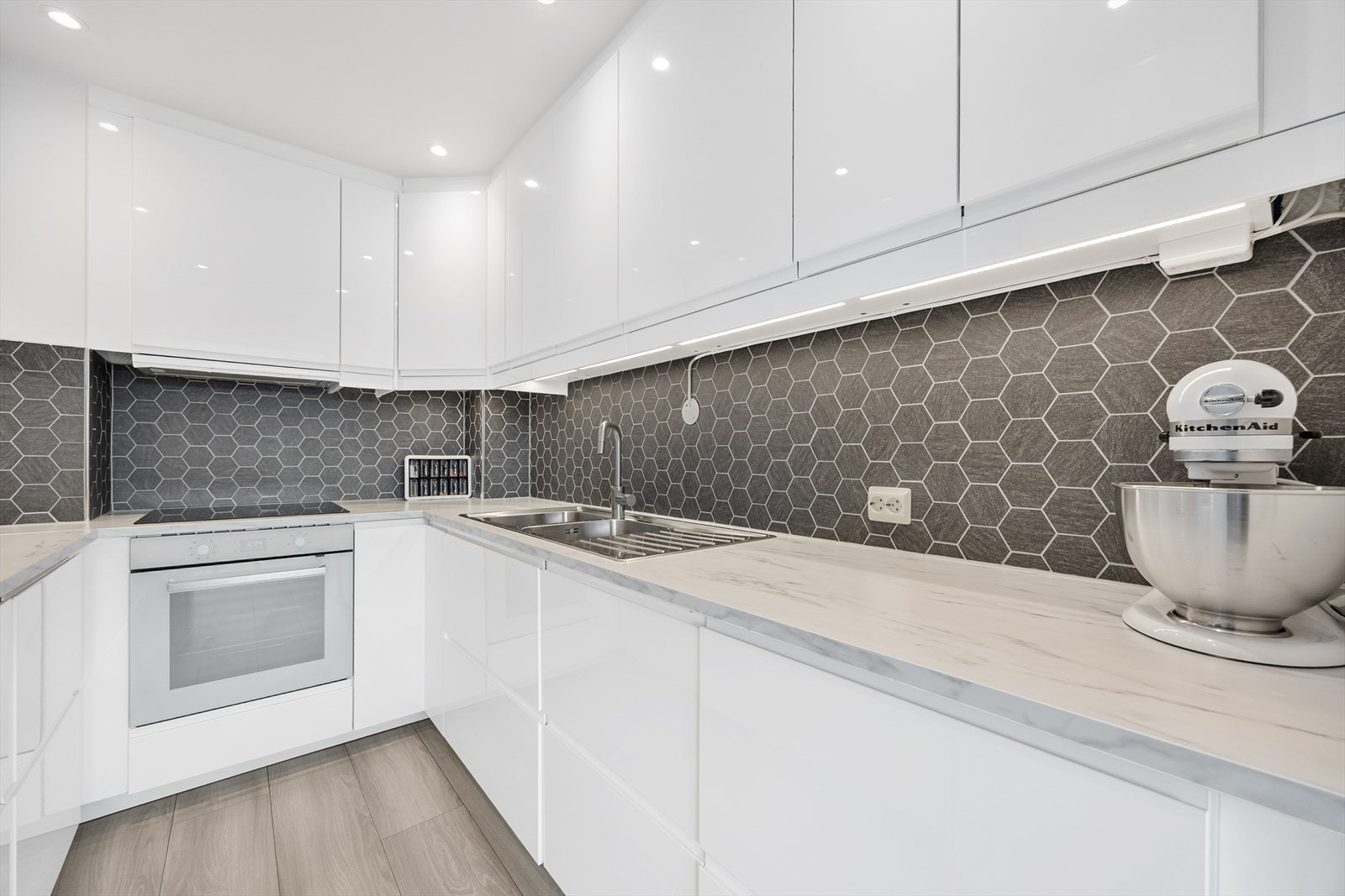 Kjøkken med rikelig benkeplass og elegant flislagt vegg. Galleribilde