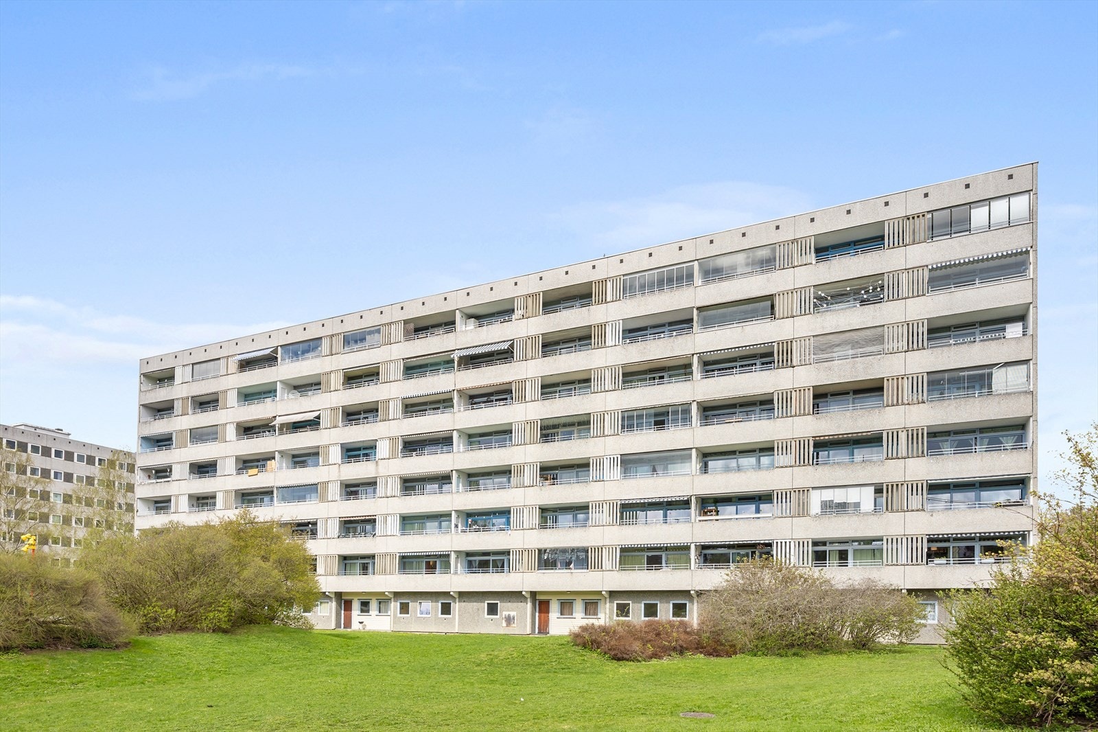 Bygning med balkonger og velpleid hage. Galleribilde