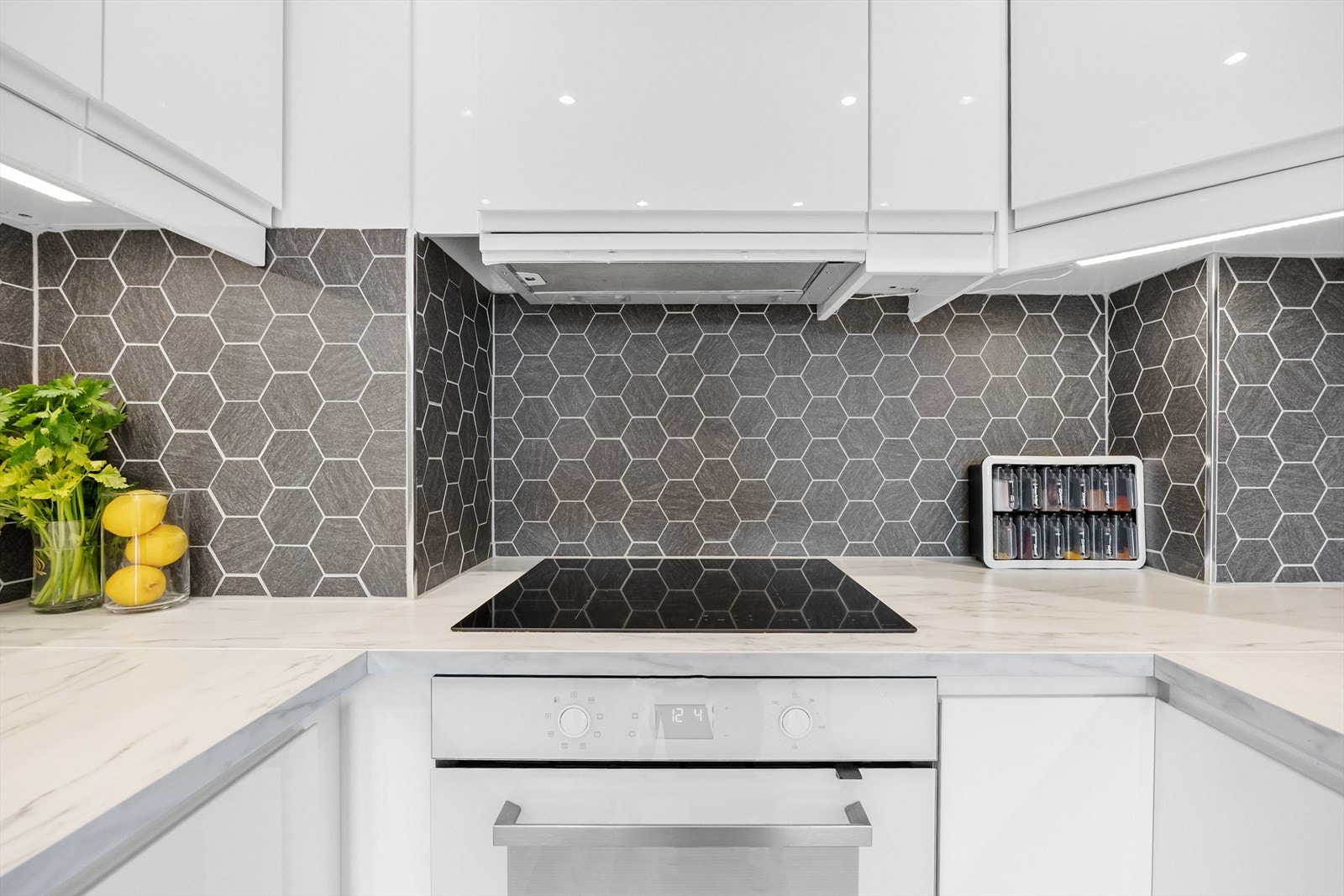 Stilrent kjøkken med moderne komfyr og ventilator. Galleribilde