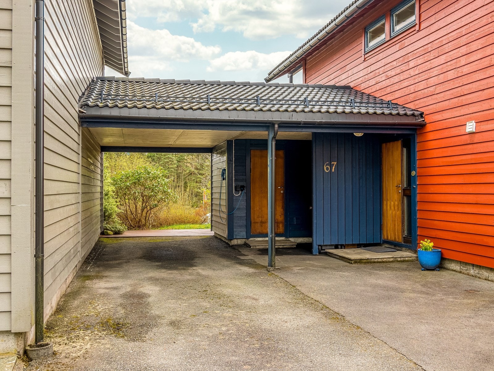 Parkering i carport med elbillader. Praktisk overbygget inngangsparti med utvendig bod. Galleribilde