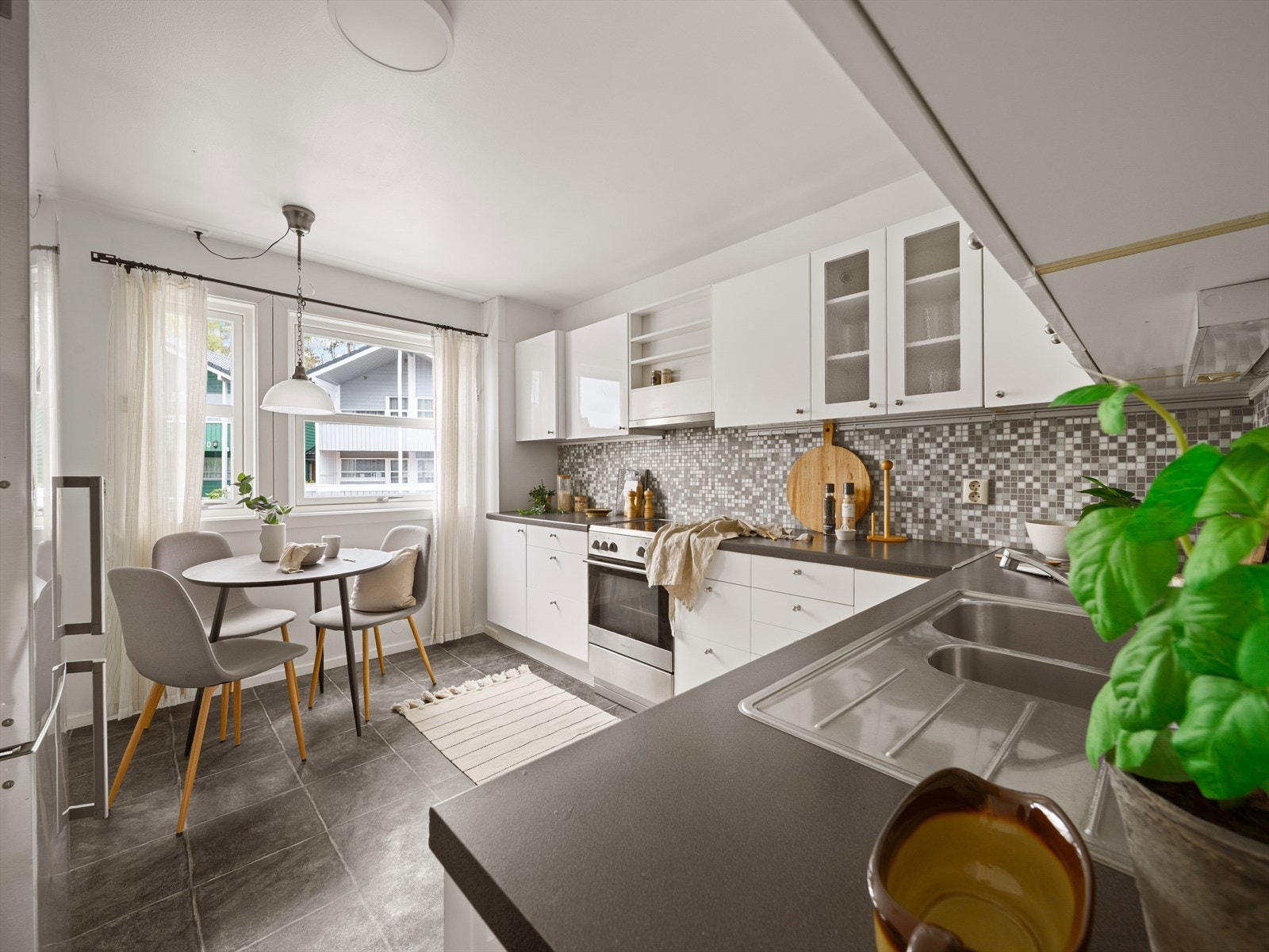 Kjøkkenet har en lys og fin innredning med slette fronter og godt med skap- og benkeplass Galleribilde