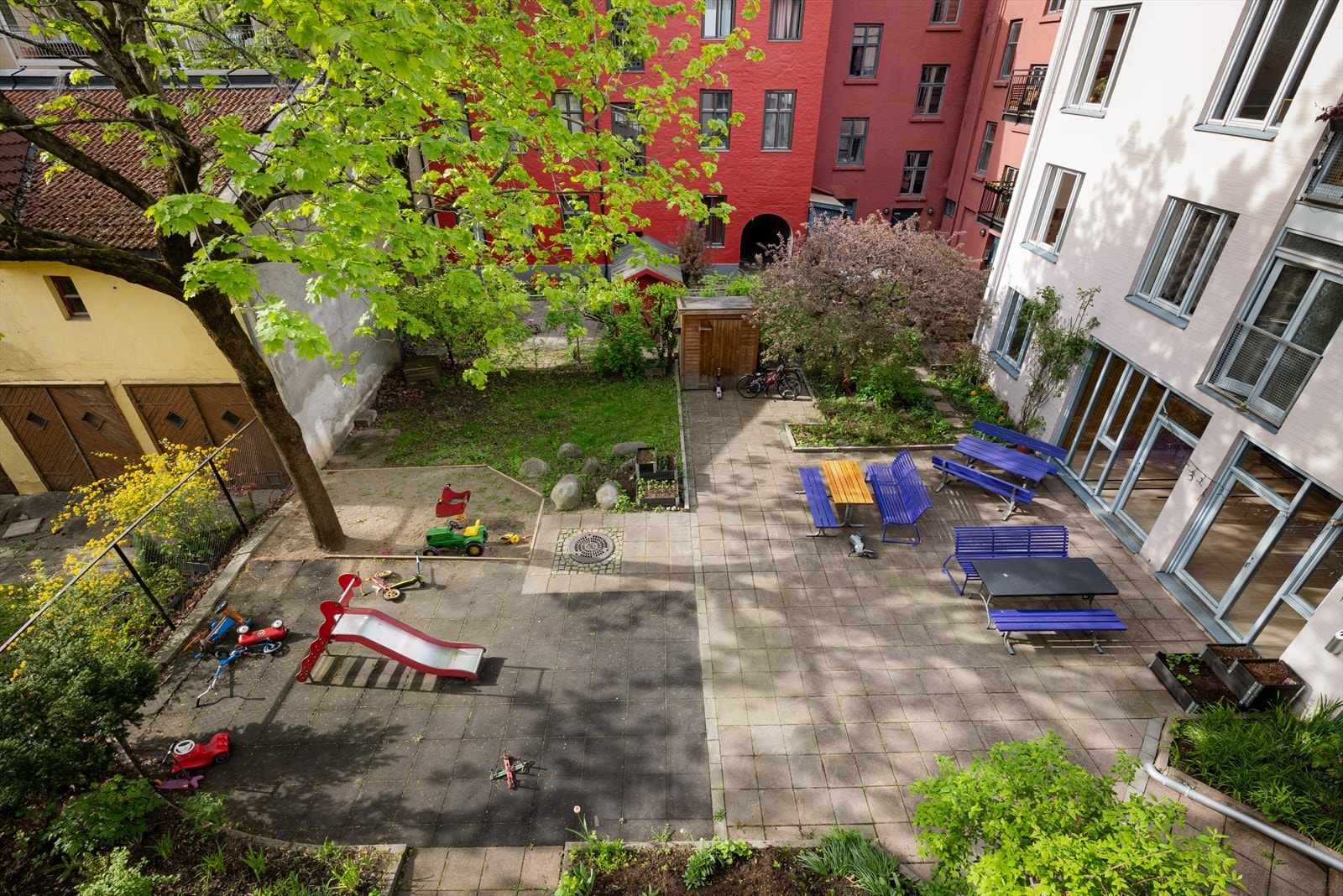 Lekeplass og benker, et koselig uteområde hvor både barn og voksne kan trives. Galleribilde