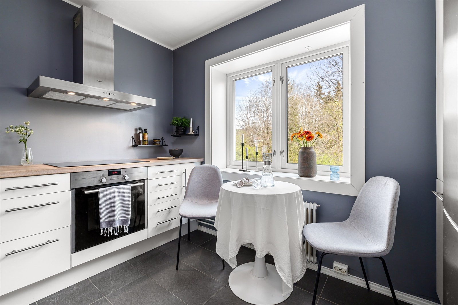 Kjøkkenet har integrerte hvitevarer som oppvaskmaskin, stekeovn og platetopp med ventilator over. Frittstående kjøleskap med frysedel Galleribilde