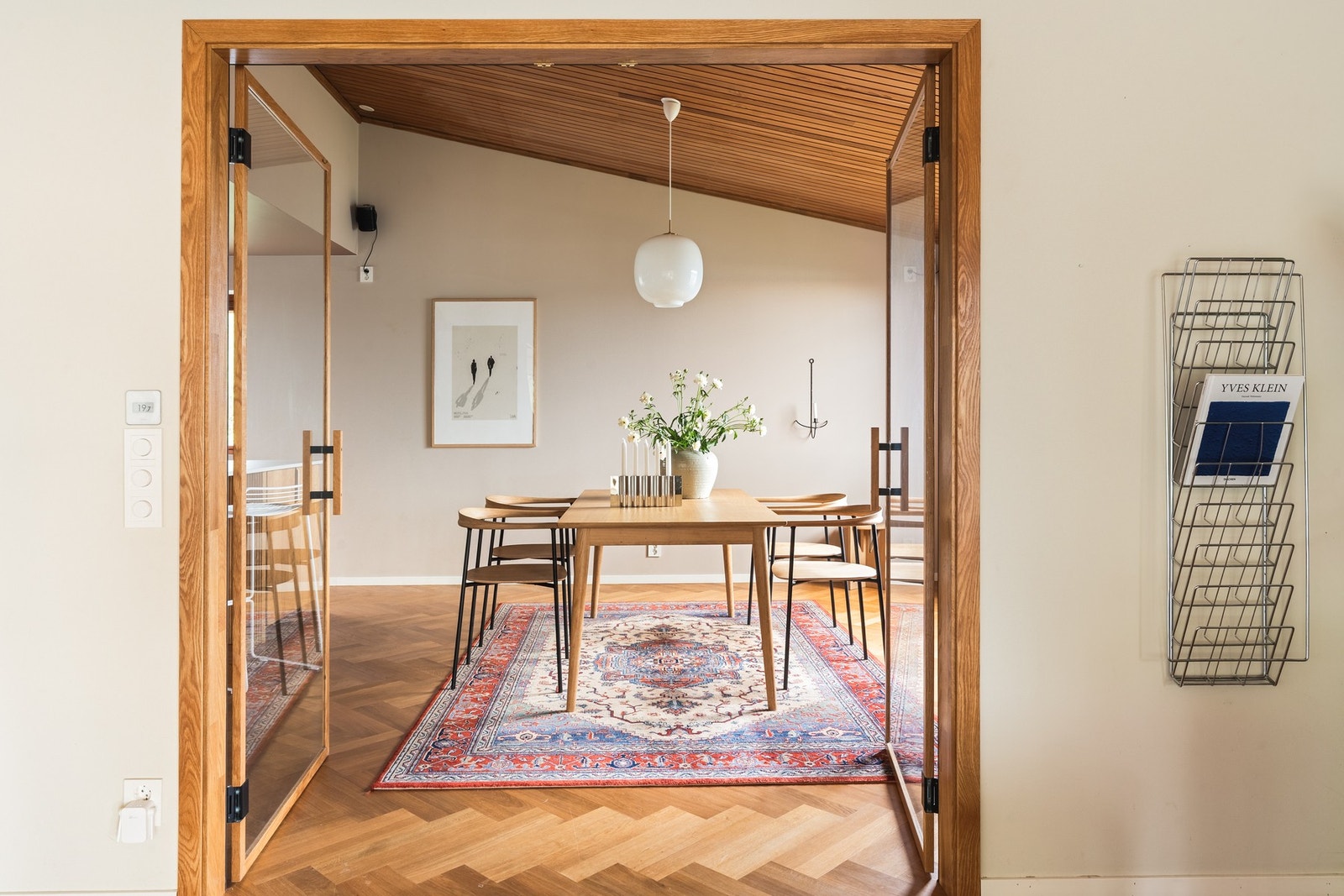 Plassbygget glassdør, spesialdesignet for nettopp dette huset, med håndtak og ramme i eik, skiller kjøkkenet fra stuen. Galleribilde