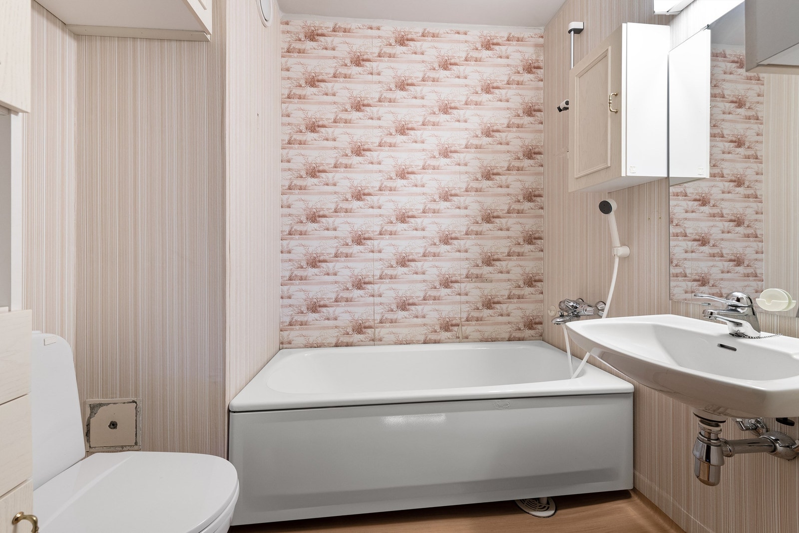 Bad med gulvbelegg på gulv med varmekabler, badekar, wc og servant Galleribilde