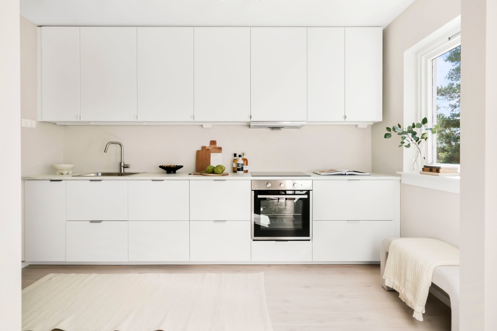 Romslig innredning fra Ikea med slette overflater i en harmonisk lys fargetone med takhøye overskap. Det er god skapplass og fint lys fra det sydvendte vinduet. Galleribilde