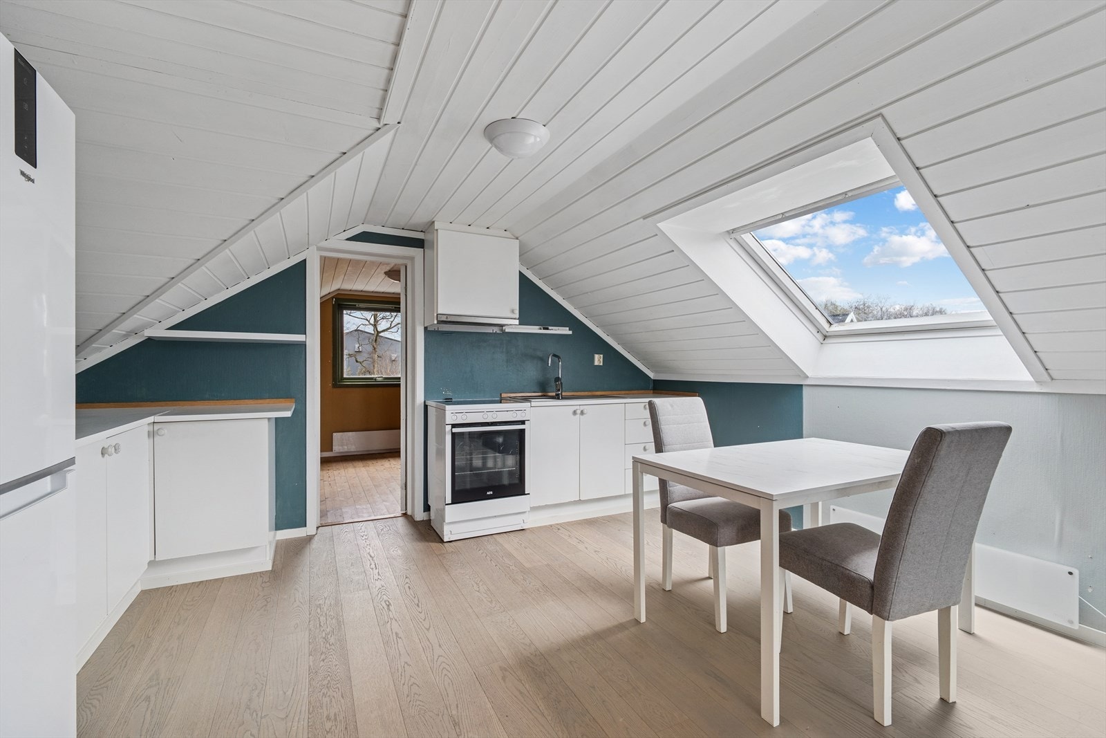 Kjøkken på loft er etablert i opprinnelig gang og kott. Innredningen er enkel, men praktisk, med plass for frittstående komfyr og kjøleskap. Lekre gulv og nyere malte overflater Galleribilde