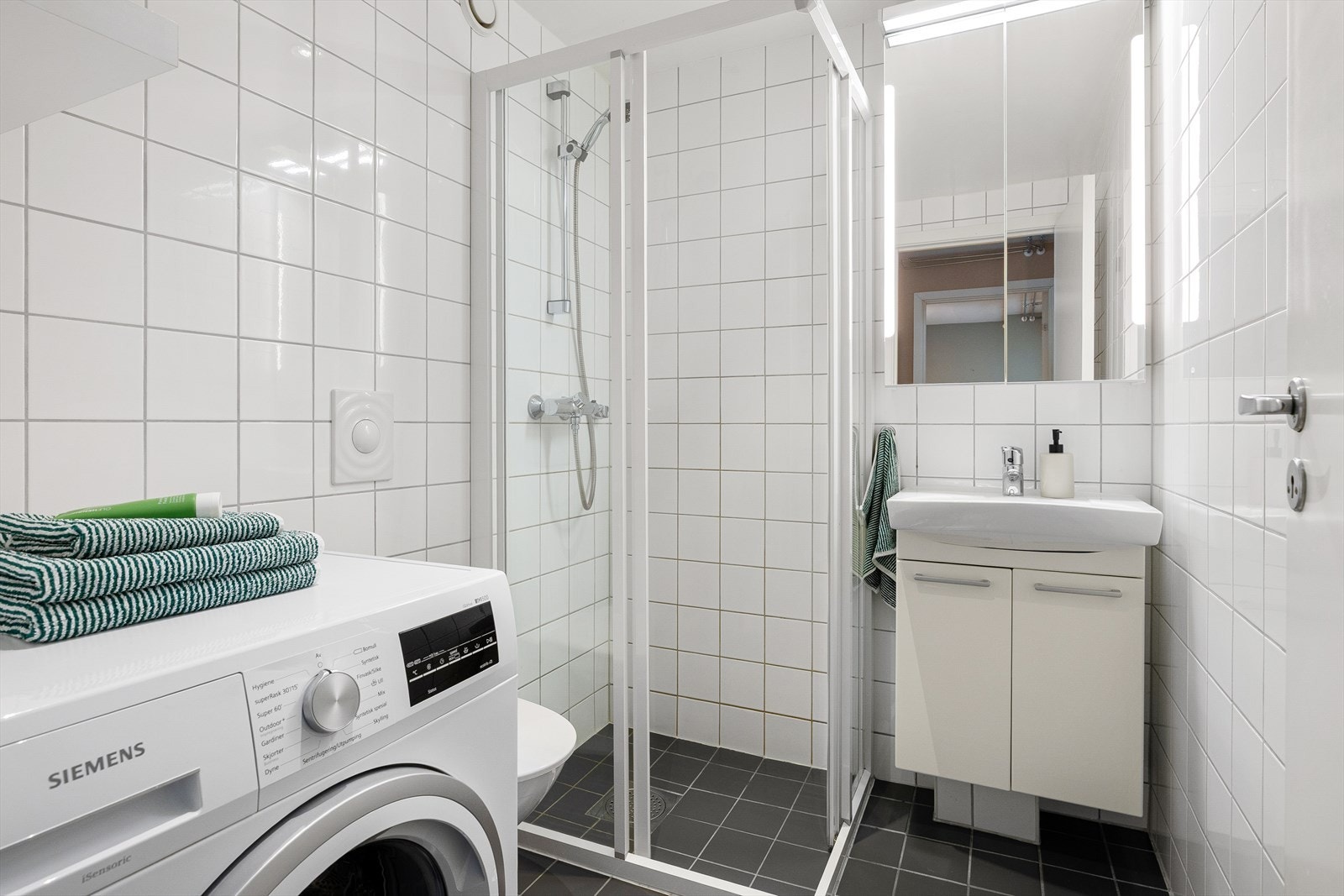 Badet er praktisk innredet, og har opplegg til vaskemaskin. Galleribilde