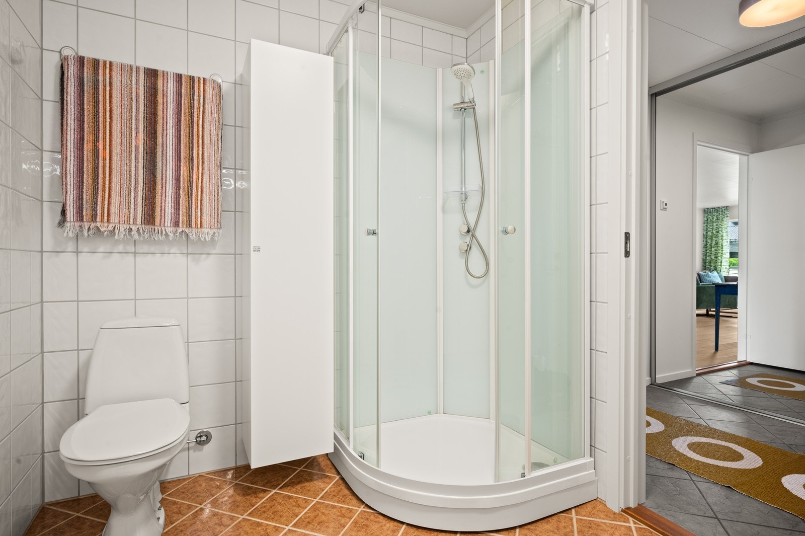 Badet i første etasje har fliser på vegger og gulv. Her er det også varmekabler i gulvet Galleribilde