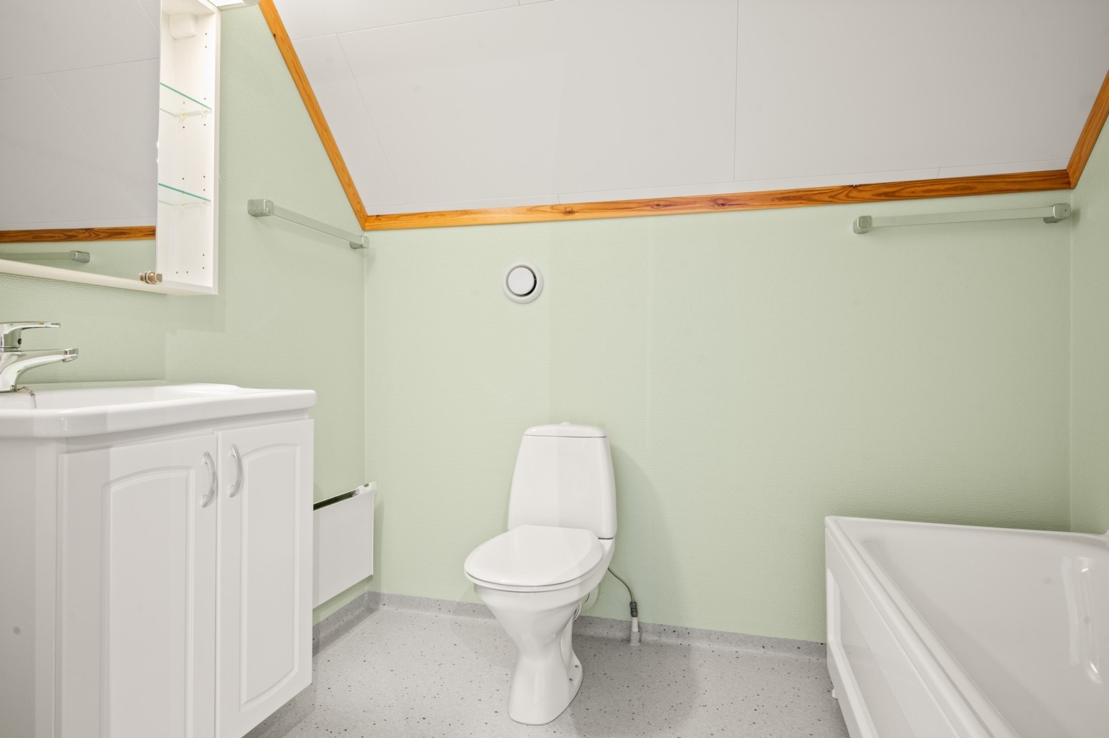 Badet i andre etasje har vinylbelegg på gulv og malte plater på vegger. Rommet har innredning med nedfelt servant, toalett og badekar Galleribilde