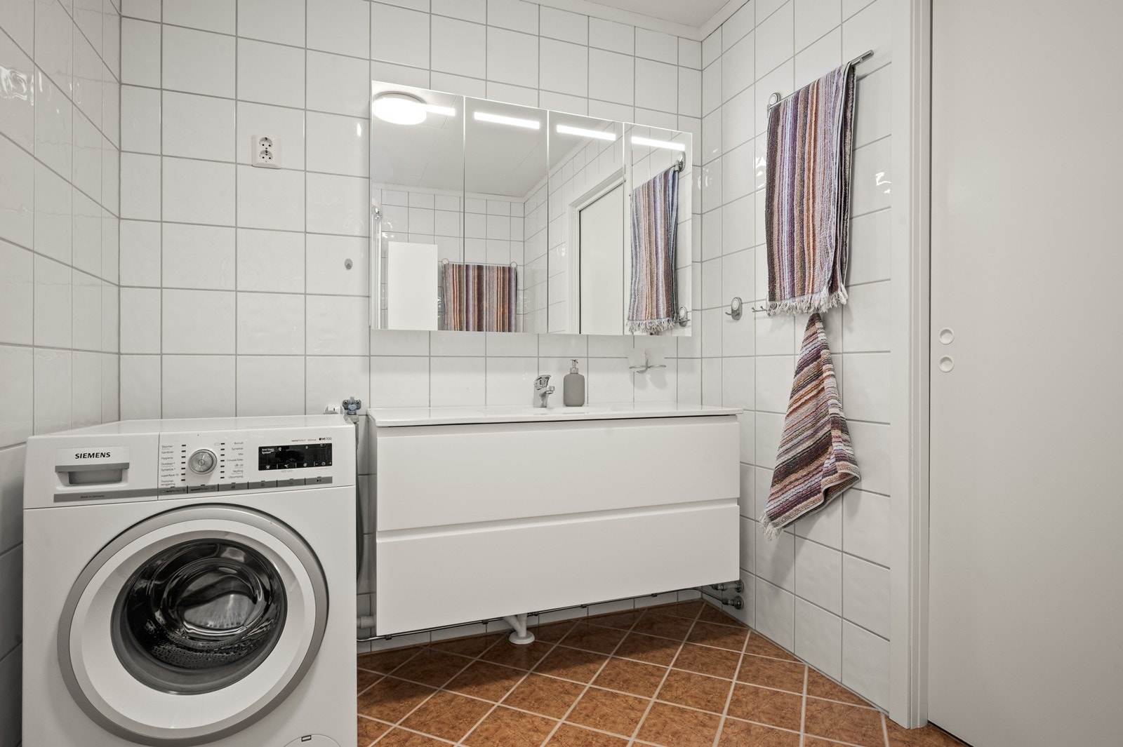 Rommet har innredning med nedfelt servant, toalett, dusjkabinett og opplegg for vaskemaskin Galleribilde