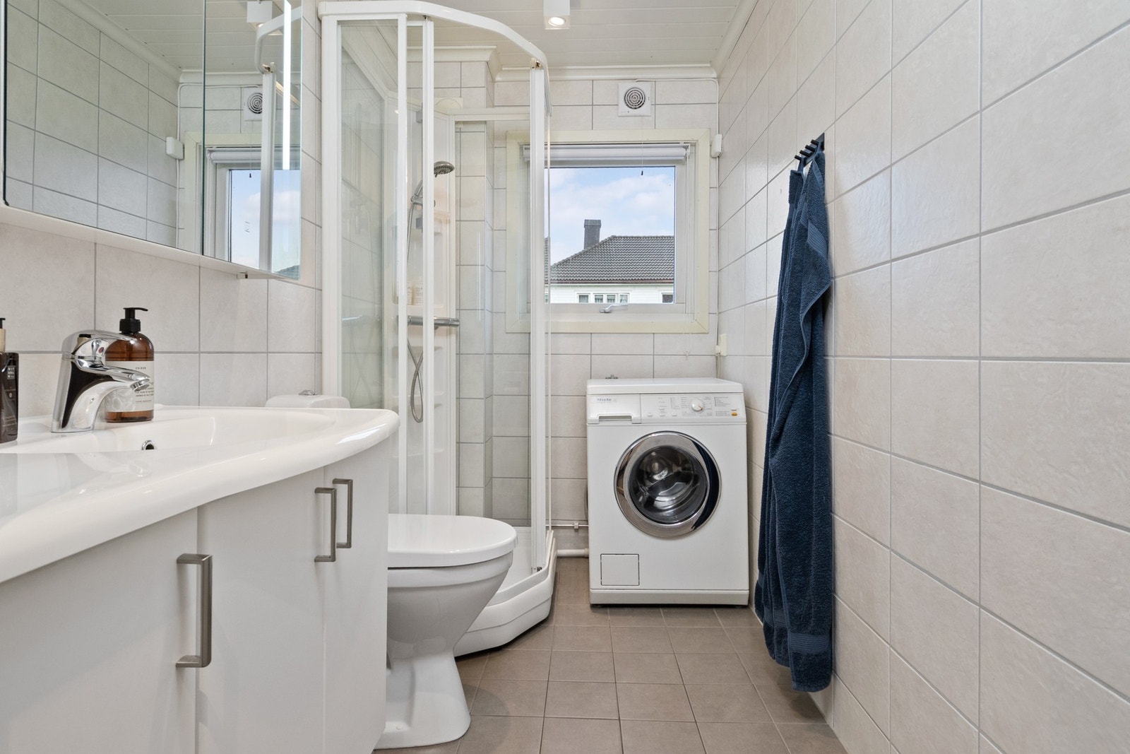 Badet ble pusset opp i 2012, og fremstår som velholdt og pent. Her er det hvite fliser på veggene, downlights i himlingen og grå fliser på gulv med gulvvarme. Galleribilde