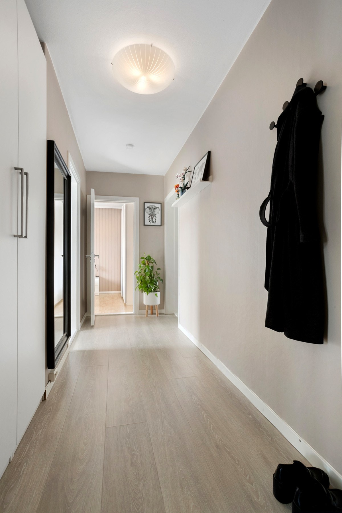 Lun og innbydende entré som ønsker deg velkommen inn i boligen. Her er det plass til å henge fra seg yttertøyet. Galleribilde