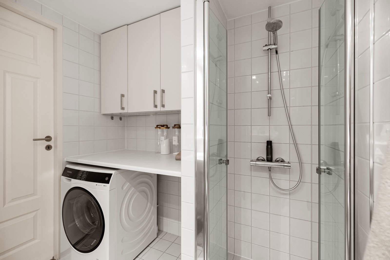 Praktisk nisje med plass og opplegg for vaskemaskin under benkeplate og god oppbevaringsplass i vegghengte skap over. Mekanisk avtrekk i himling som justeres fra kjøkken. Galleribilde