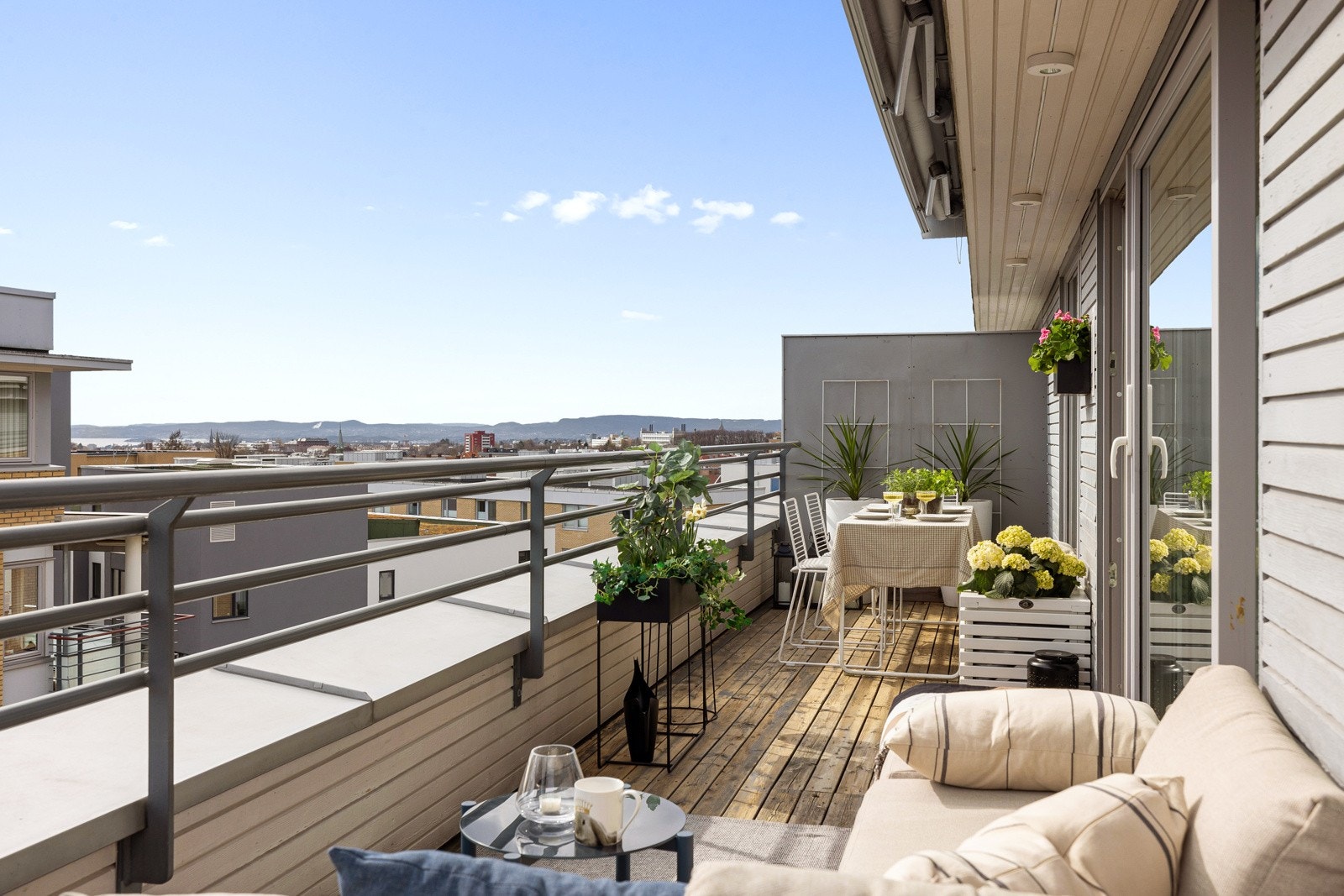 Terrassen strekker seg langs to sider av leiligheten, har terrassebord på gulv og god plass til flere sittegrupper og grill om ønskelig. Galleribilde