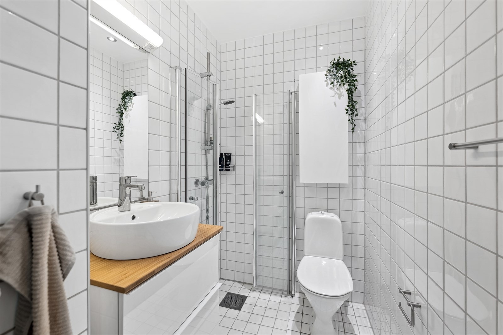 Pent baderom med flislagt gulv med varmekabel og flislagte vegger. Galleribilde