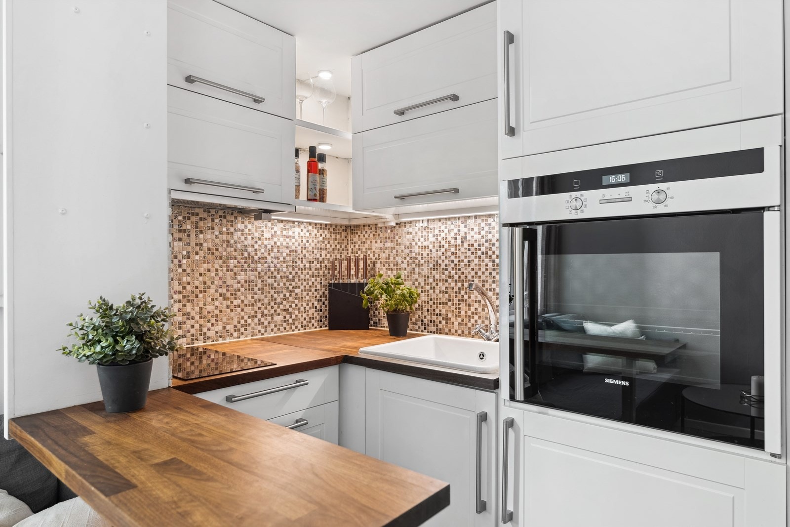 Kjøkkenet har innredning med glatte fronter og benkeplate av laminat. Det er flislagt mellom benkeplate og overskap, samt belysning under overskap. Galleribilde