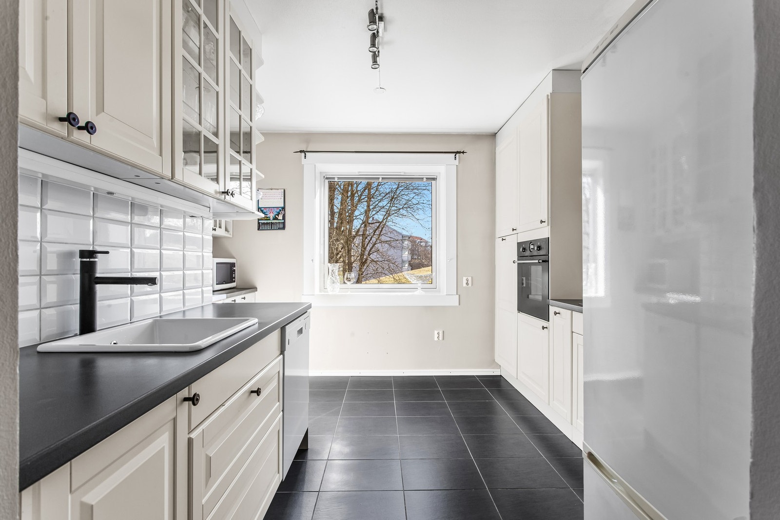 Leiligheten har et stort adskilt kjøkken med takhøy inredning og profilerte fronter Galleribilde