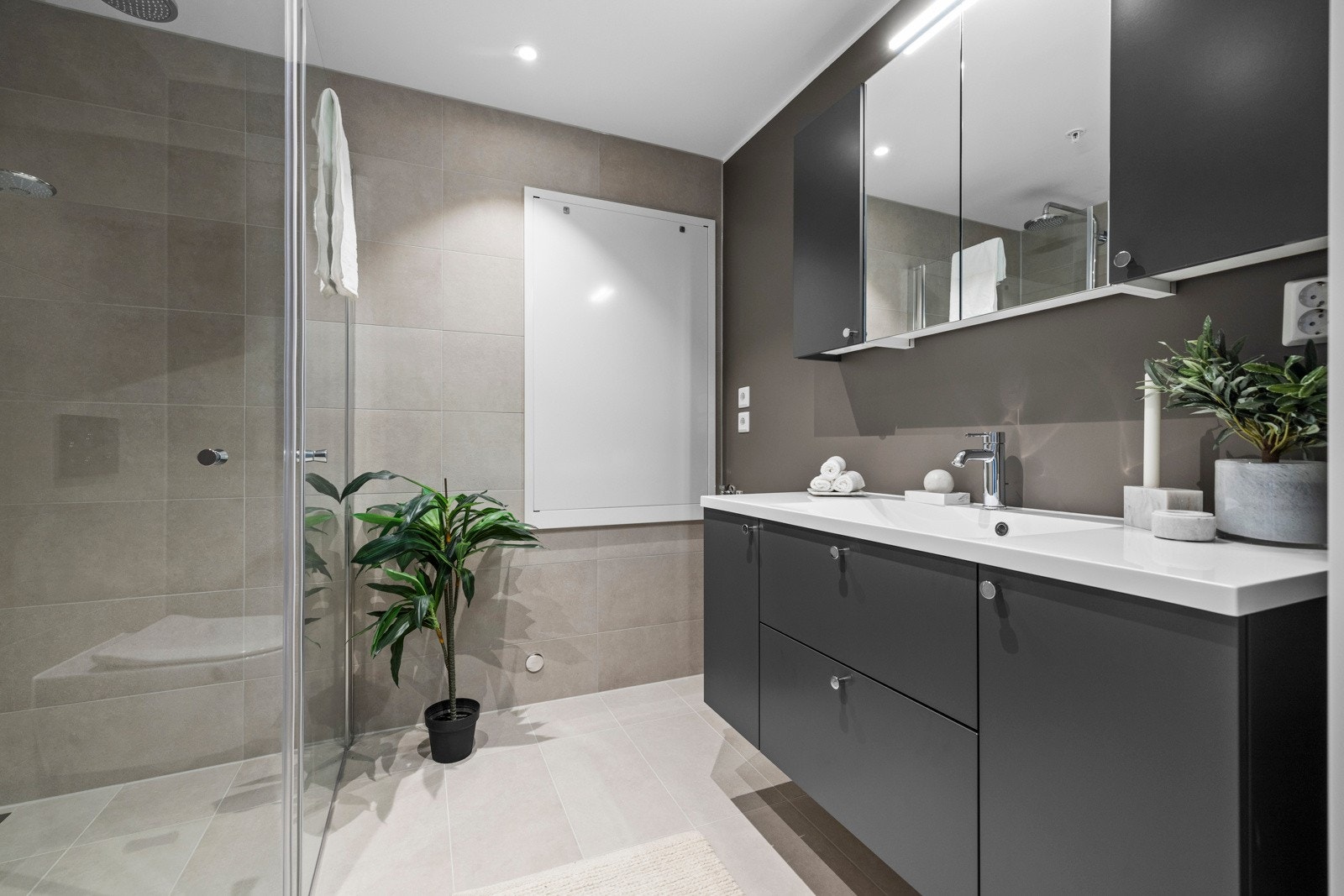 Det moderne badet er smakfullt innredet med nødvendige fasiliteter, inkludert opplegg for vaskemaskin/kondenstørketrommel. Galleribilde