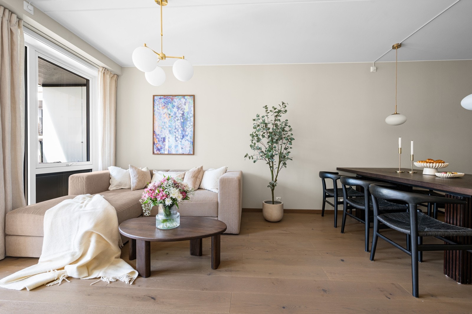 Leiligheten har en lys og innbydende stue med enstavs eikeparkett og malte, lyse veggflater som gir et moderne og delikat uttrykk Galleribilde