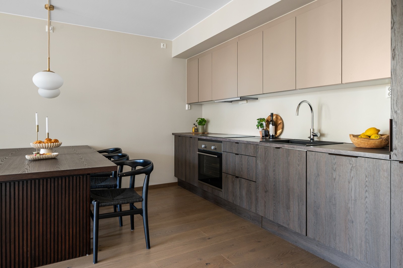 Leiligheten har et moderne og stilrent kjøkken med glatte skapfronter i en dus fargetone som gir et elegant uttrykk Galleribilde