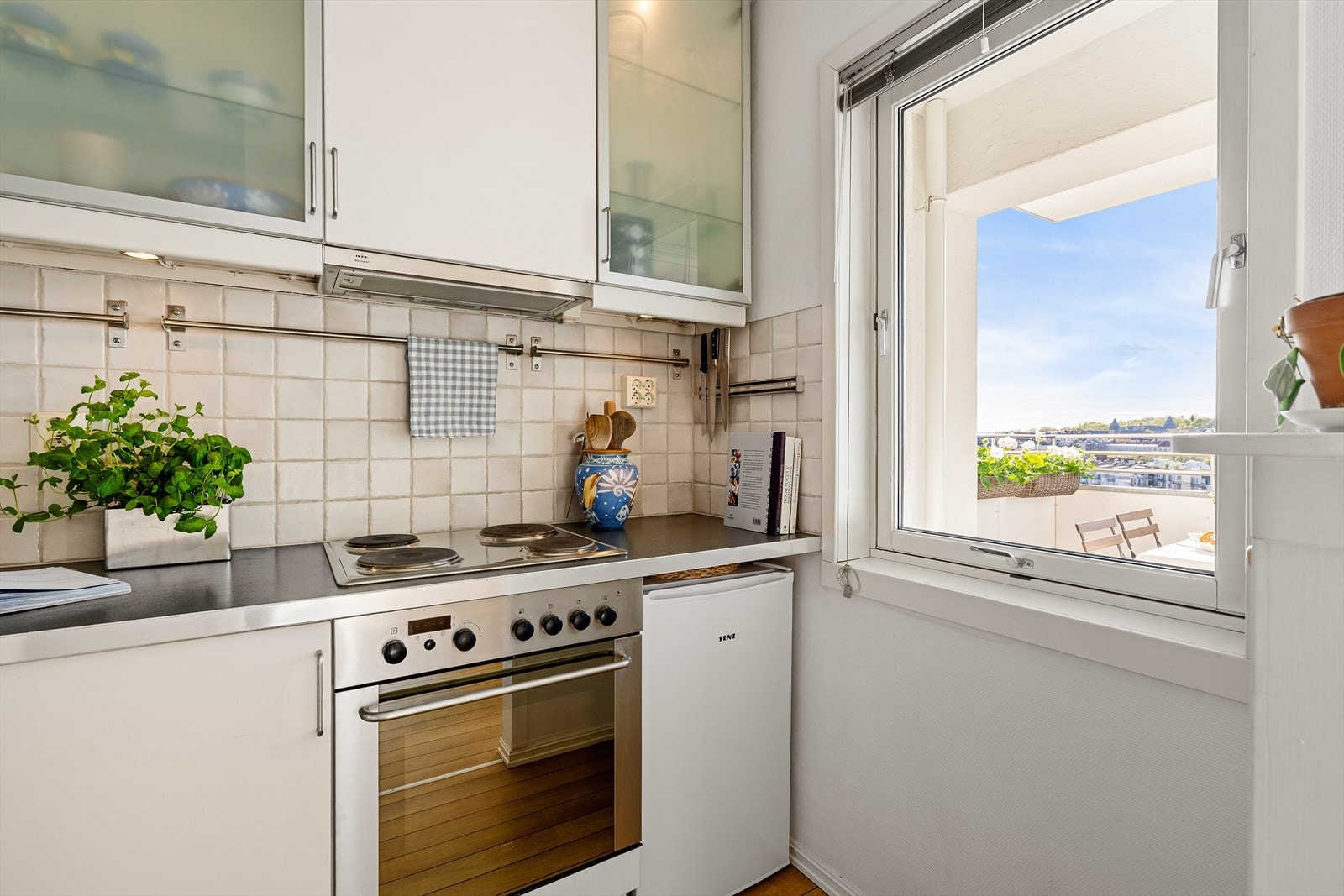 Det er godt med lagringsplass, , fliser mellom overskap og laminert benkeplate, kum med ettgreps blandebatteri og integrert oppvaskmaskin. Kullfiltervifte over integrert koketopp/ovn. Galleribilde