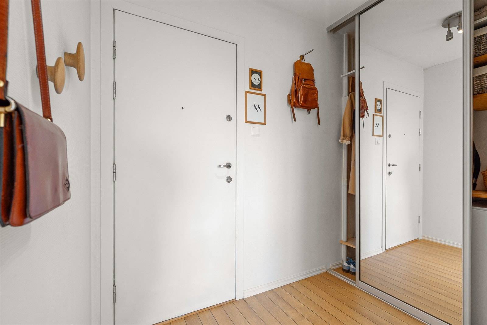 Entréen er lys og romslig med skyvedørsgarderober med speilfronter. I garderobeskapet er det plass til fryser. Galleribilde
