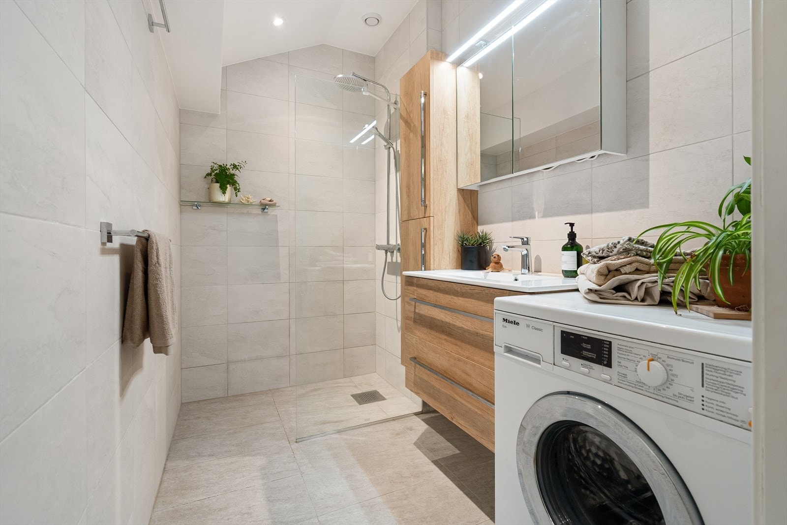 Delikat og innbydende baderom fra 2019. Det er opplegg for vaskemaskin. Galleribilde