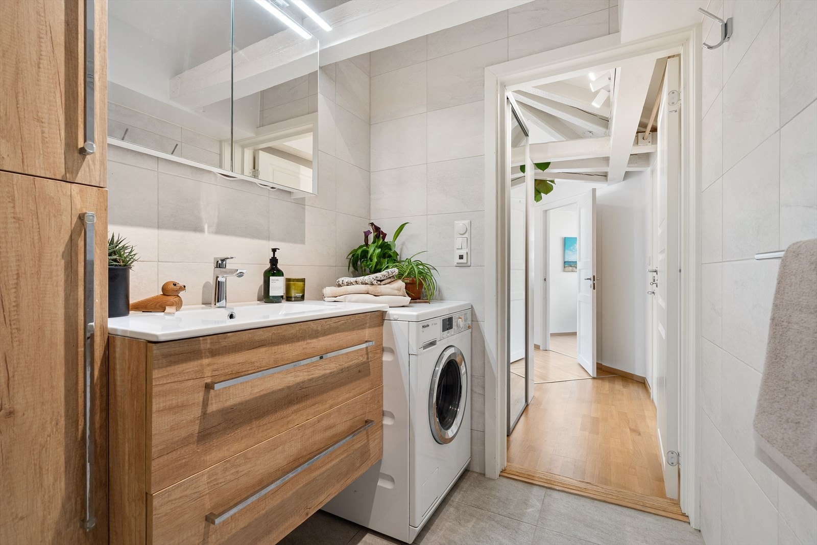 Rommet er utstyr med dusjnisje med fast glassvegg og baderomsinnredning med skuffer, servant med ett greps blandebatteri fra Hansgrohe og vegghengt speilskap med belysning. Galleribilde