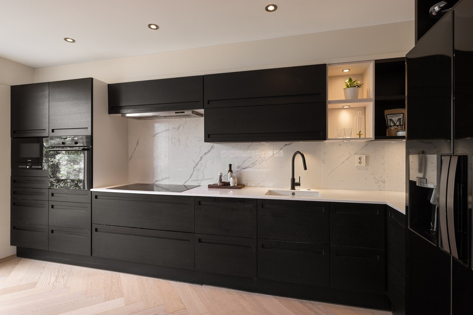 Kjøkkenet byr på integrerte hvitevarer som komfyr, mikrobølgeovn, platetopp, oppvaskmaskin og kjøkkenventilator tilkoblet avtrekkskanal. Galleribilde