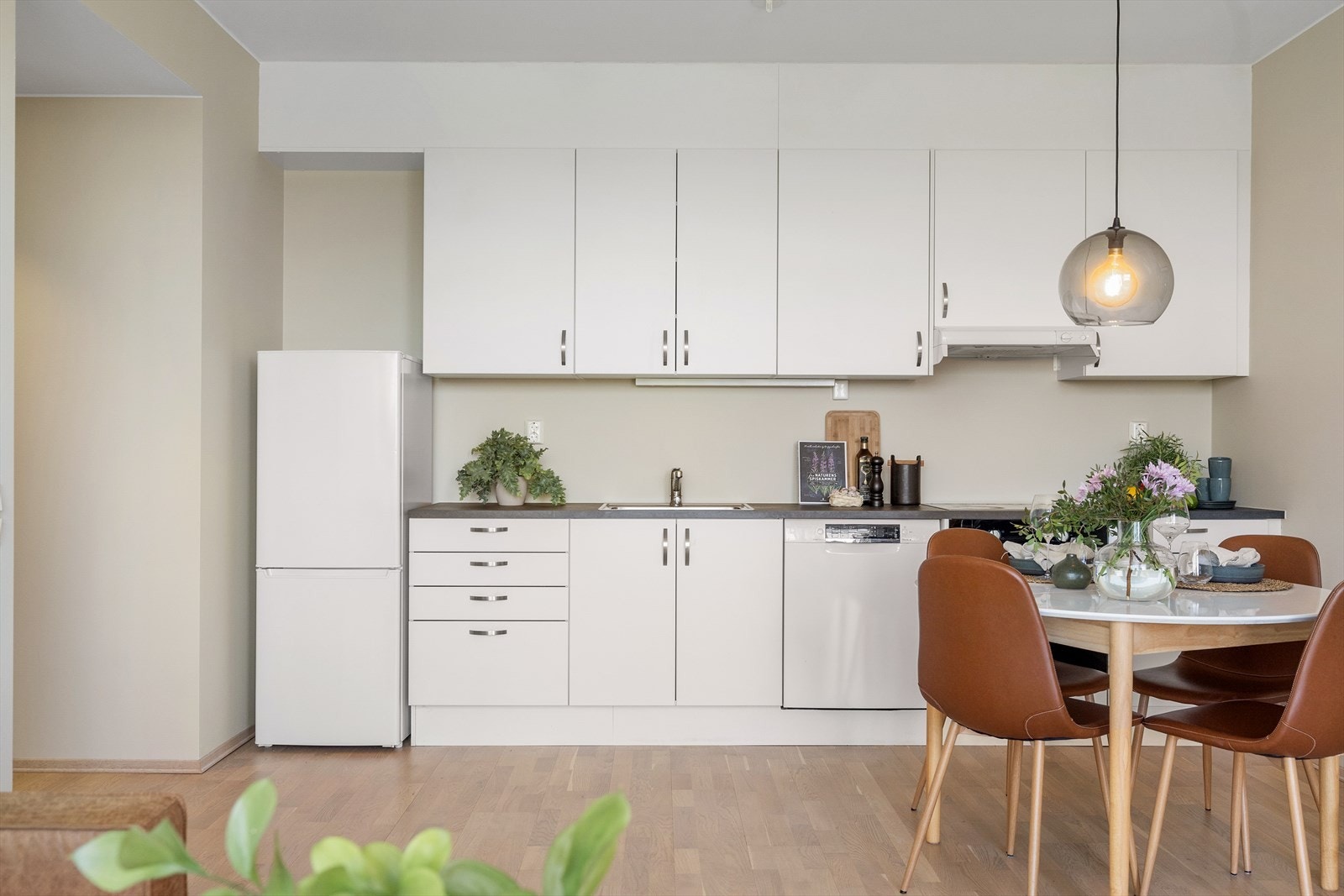 Kjøkkenet gir et lyst og luftig inntrykk, med god skap- og benkeplass som gjør matlagingen praktisk. Galleribilde