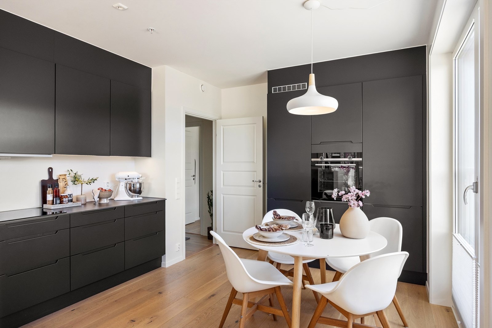 Stilrent HTH-kjøkken med glatte fronter og benkeplate i stein med underlimt kum. Kjøkkenet har rikelig med både skap- og benkeplass. Galleribilde