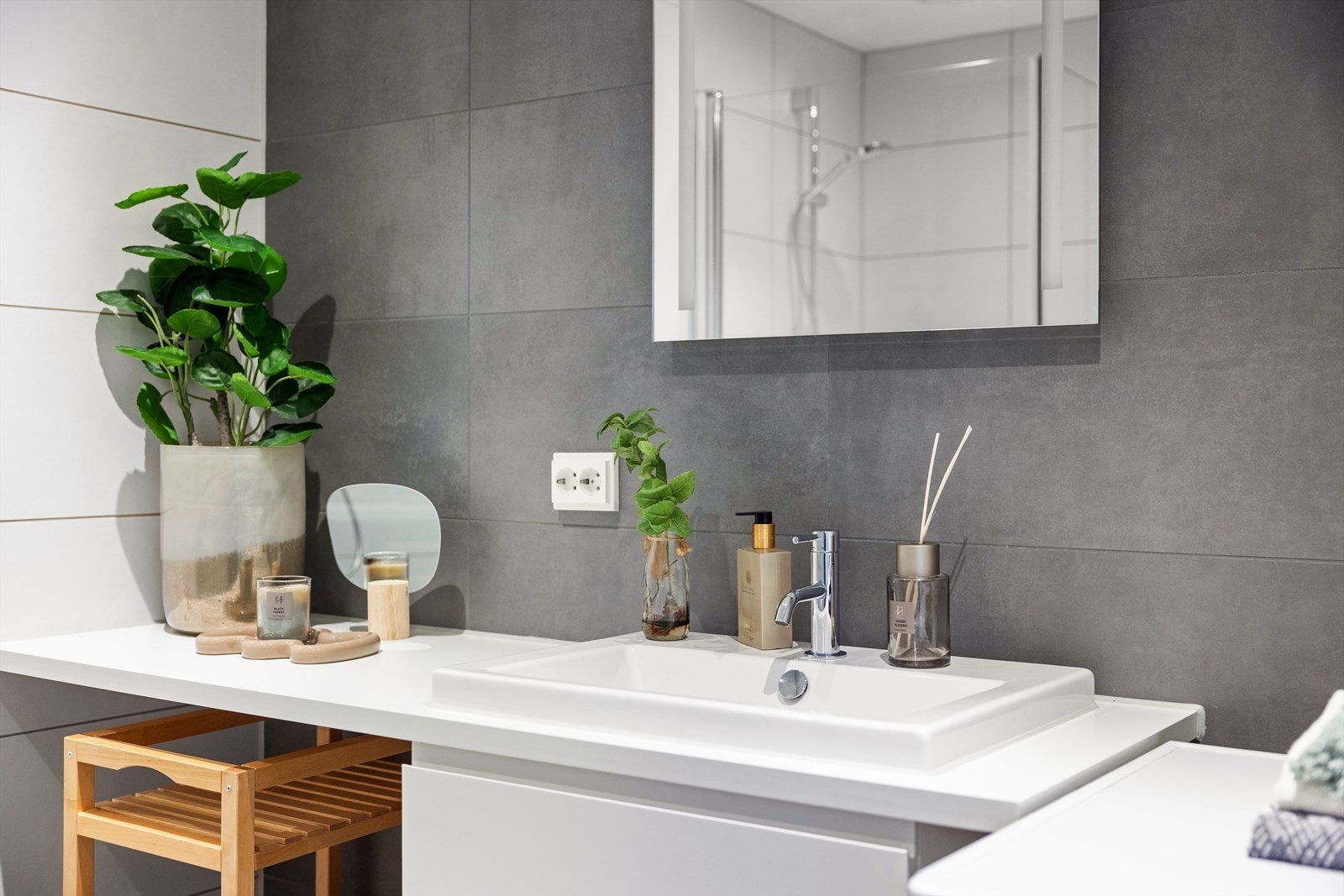 Benkeplate med nedfelt servant og underskap med glatte, folierte fronter. Over servanten er det montert speilskap med integrert belysning. Galleribilde