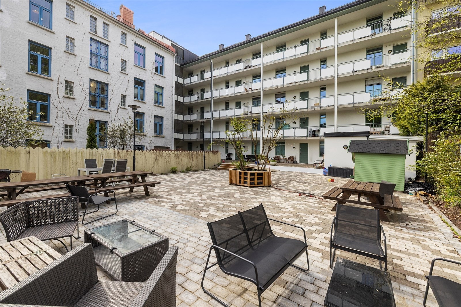 Bakgården ble oppgradert i 2024 med ny steinbelegning og prydbusker. Det er møblement og grill til felles bruk for borettslaget. Galleribilde