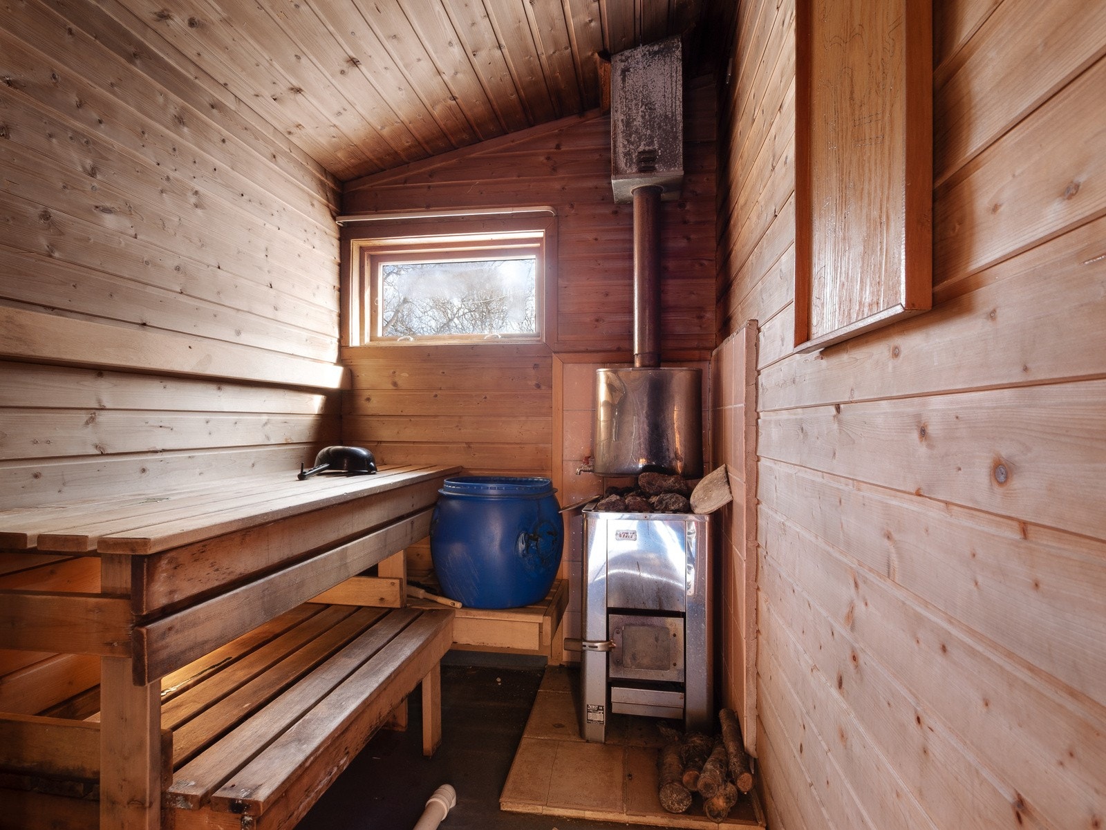 Den vedfyrte badstua ligger til høyre når man kommer inn i hytta Galleribilde