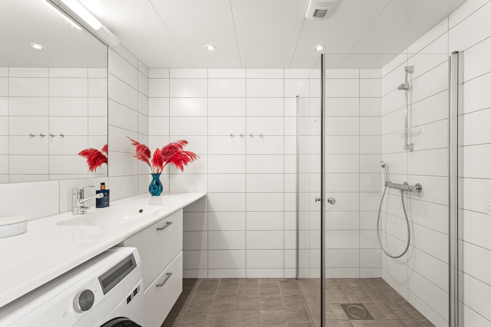 Delikat og moderne baderom fra byggeår (2020) med gulvvarme, downlights, servant med underskap og opplegg vaskemaskin Galleribilde