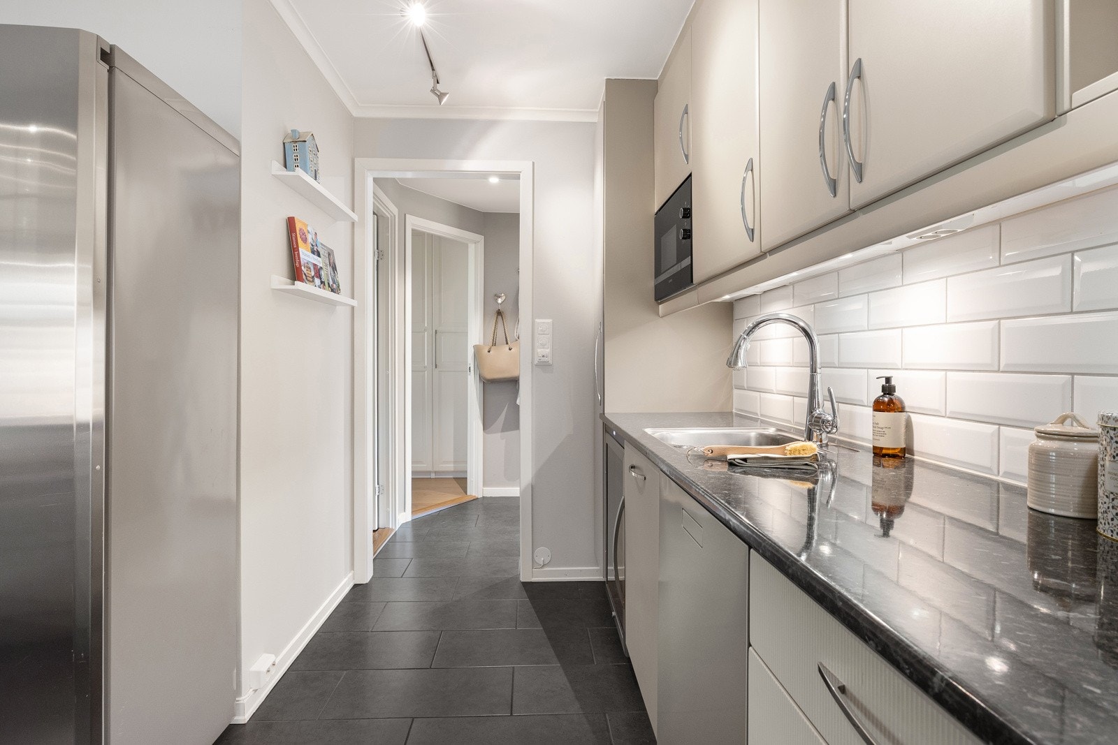 Hvite metrofliser over benken understreker det klassiske uttrykket, og gulvflisene er lagt sømløst inn i entreen. Galleribilde